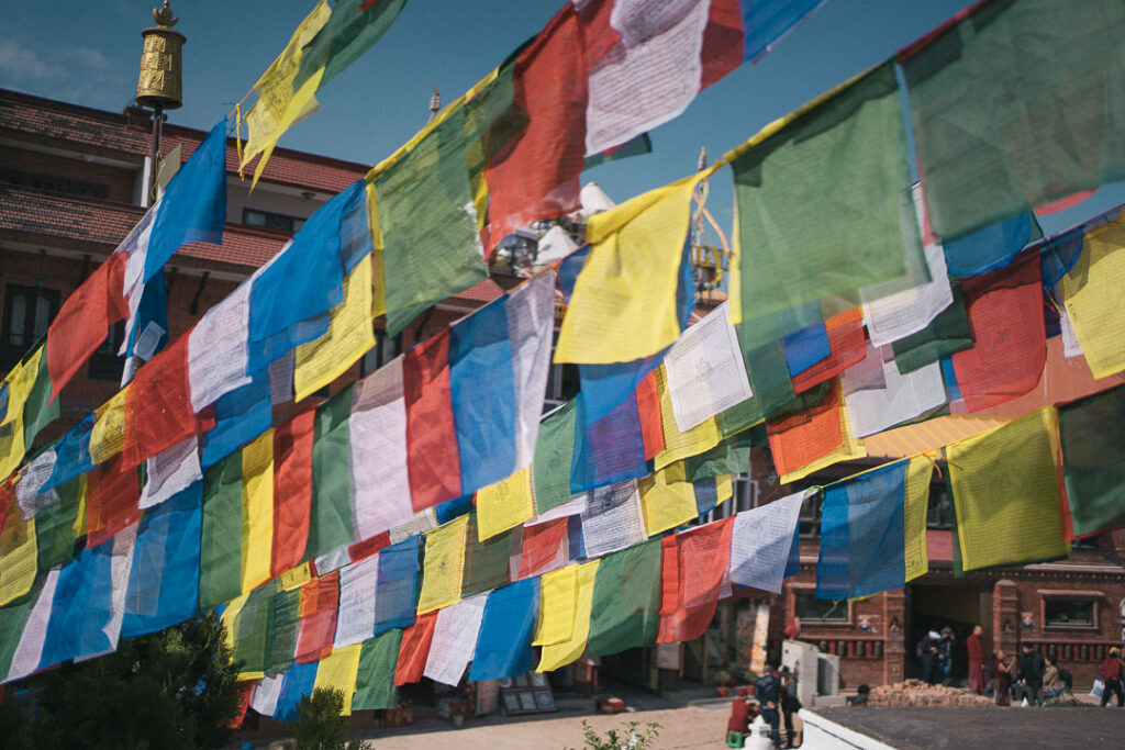 仏塔から放射状に広がる五色の祈祷旗（タルチョ）が風になびいている様子