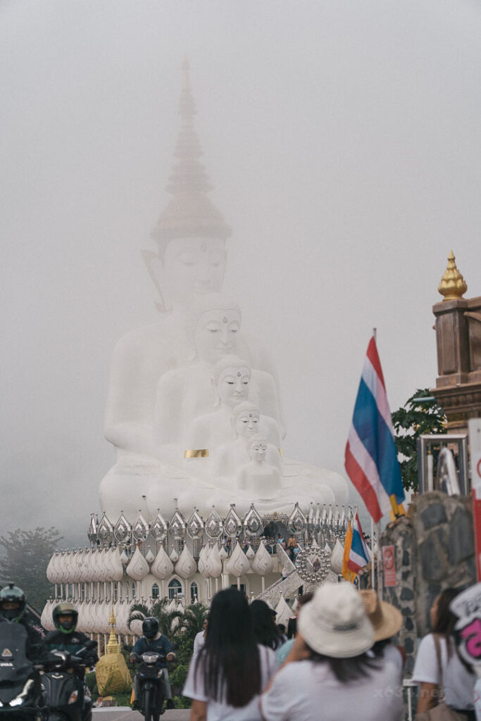 曇り空の中、もやに浮かび上がるように見える白い仏像。カオコーの山中にて。